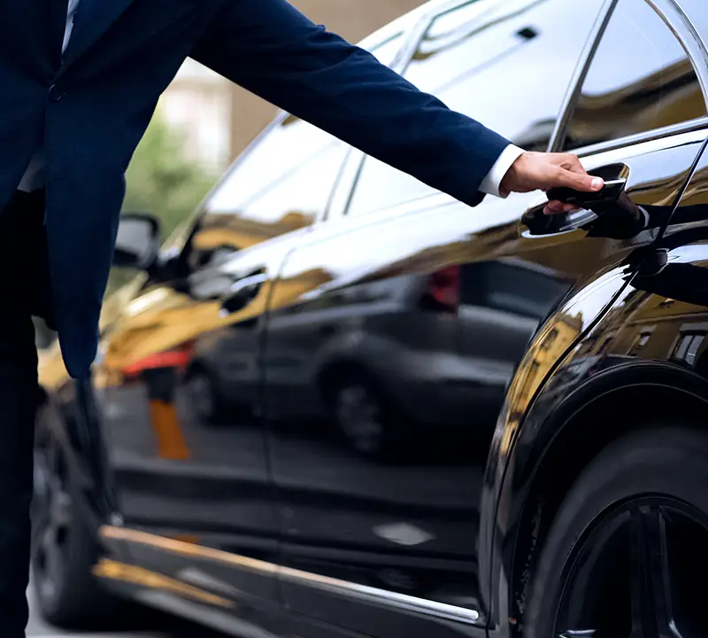 Chauffeur qui ouvre la porte de sa voiture
